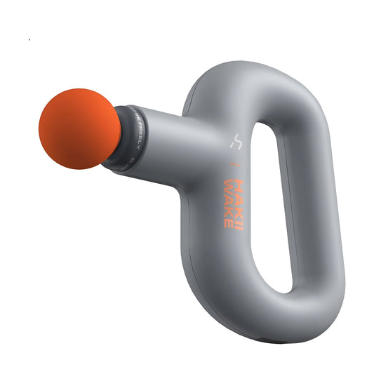 Gray massage gun with an orange ball head on a white background