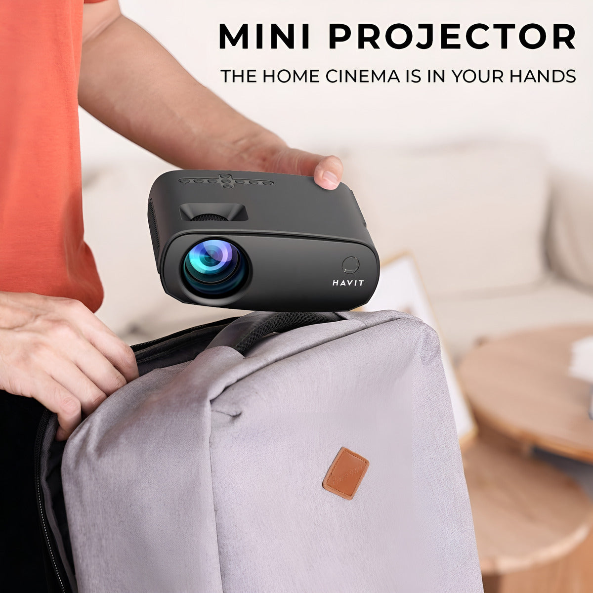 Mini projector held by a person with text 'The home cinema is in your hands' and 'HAVIT' branding.