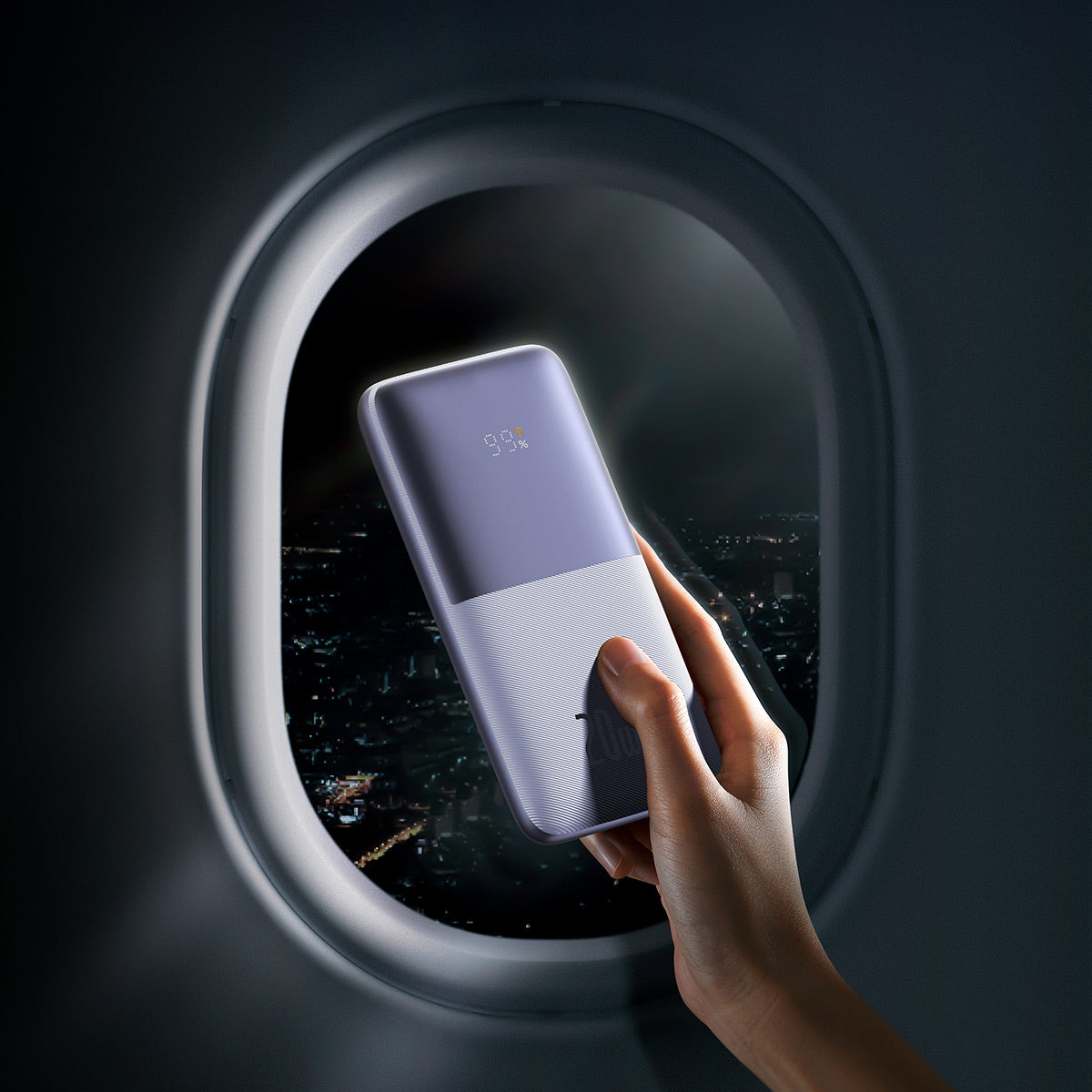 Baseus Bipow Pro Digital Display Fast Charge Power Bank 10000mAh 20W Hand holding a smartphone with a reflective screen in front of an airplane window view.