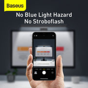 Hand holding a smartphone with camera app displayed, showing no blue light hazard and no stroboflash text, with Baseus logo.