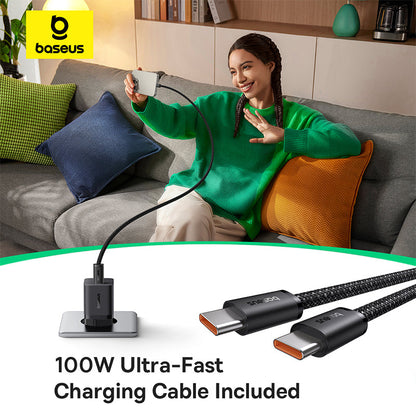 Woman sitting on a couch using a smartphone with a baseus charging cable, surrounded by colorful pillows.