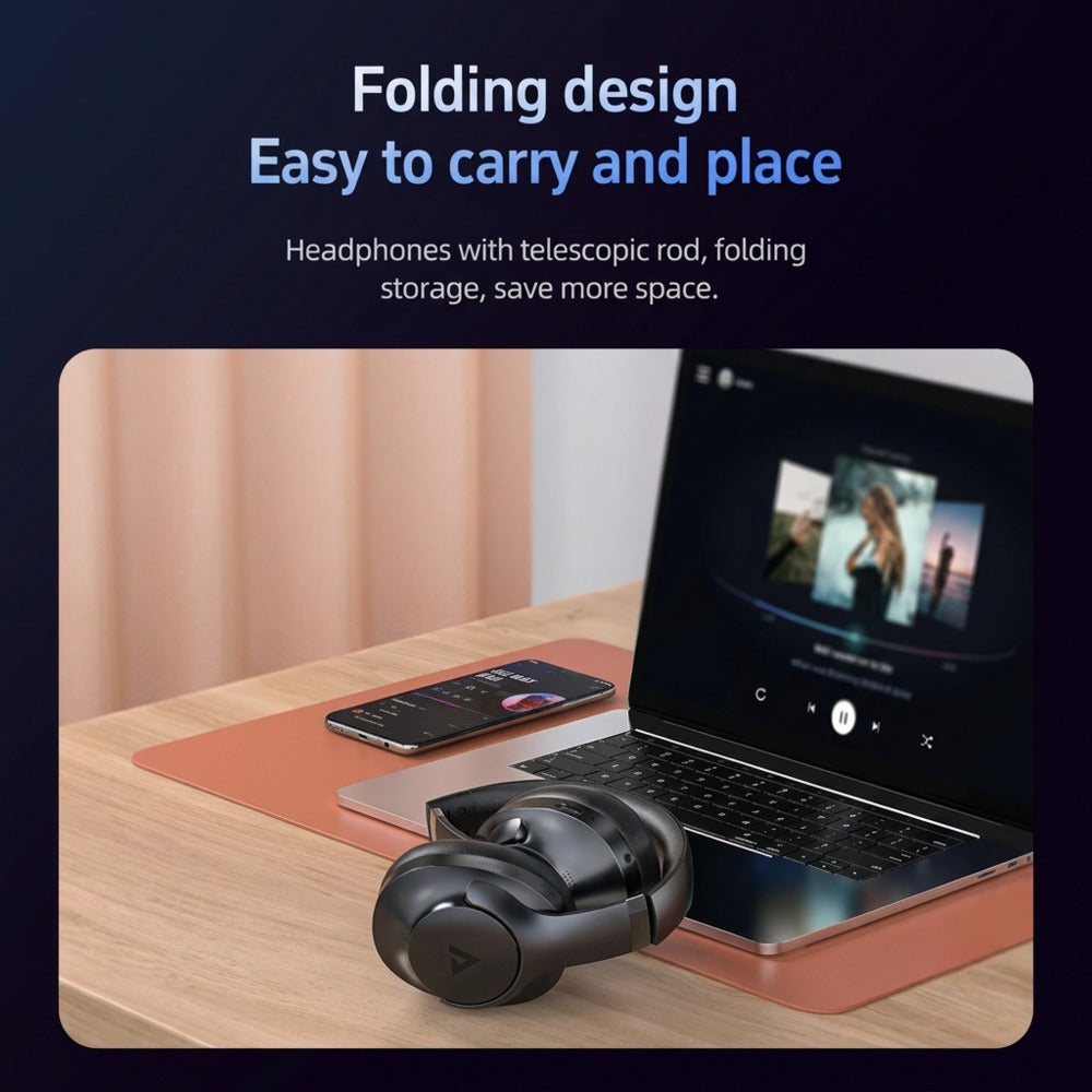 Folding headphones with a telescopic rod on a desk next to a laptop.