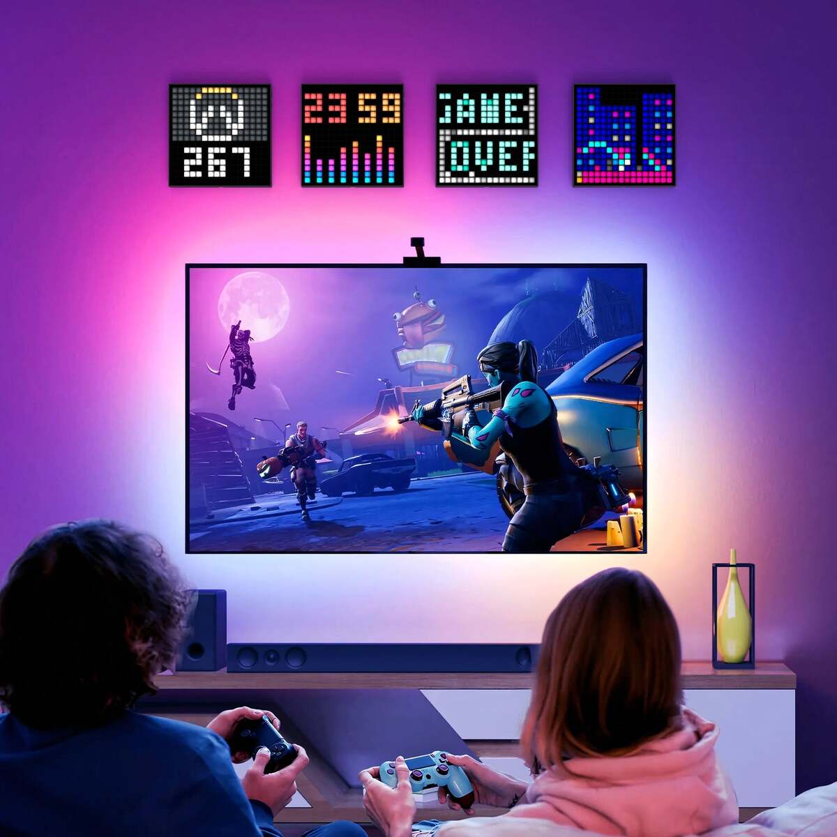 Two people playing video games in a room with colorful LED wall displays.