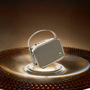 A portable silver and black speaker with a built-in handle, shown floating above a glowing circular platform on a dark brown background.