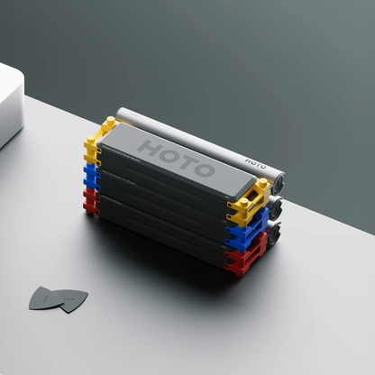 Stack of black rectangular blocks with colorful edges on a gray surface, featuring the brand 'HOTO'.