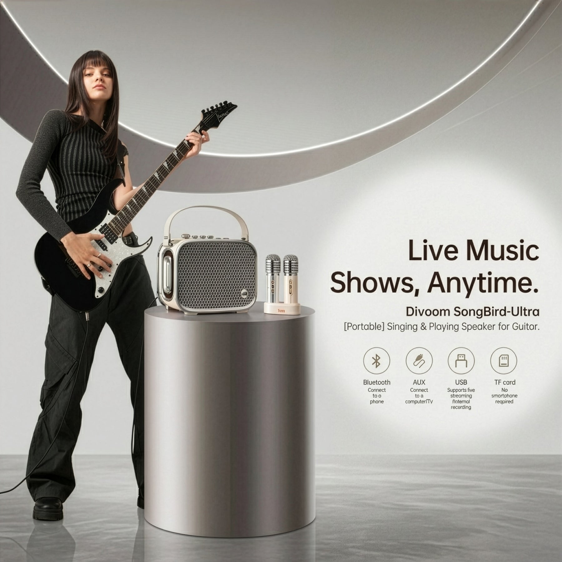 A woman holding a black electric guitar stands beside a silver cylindrical pedestal displaying a portable Bluetooth speaker and two microphones. The background is a clean studio setting with a large circular architectural element, and text on the right reads 'Live Music Shows, Anytime.
