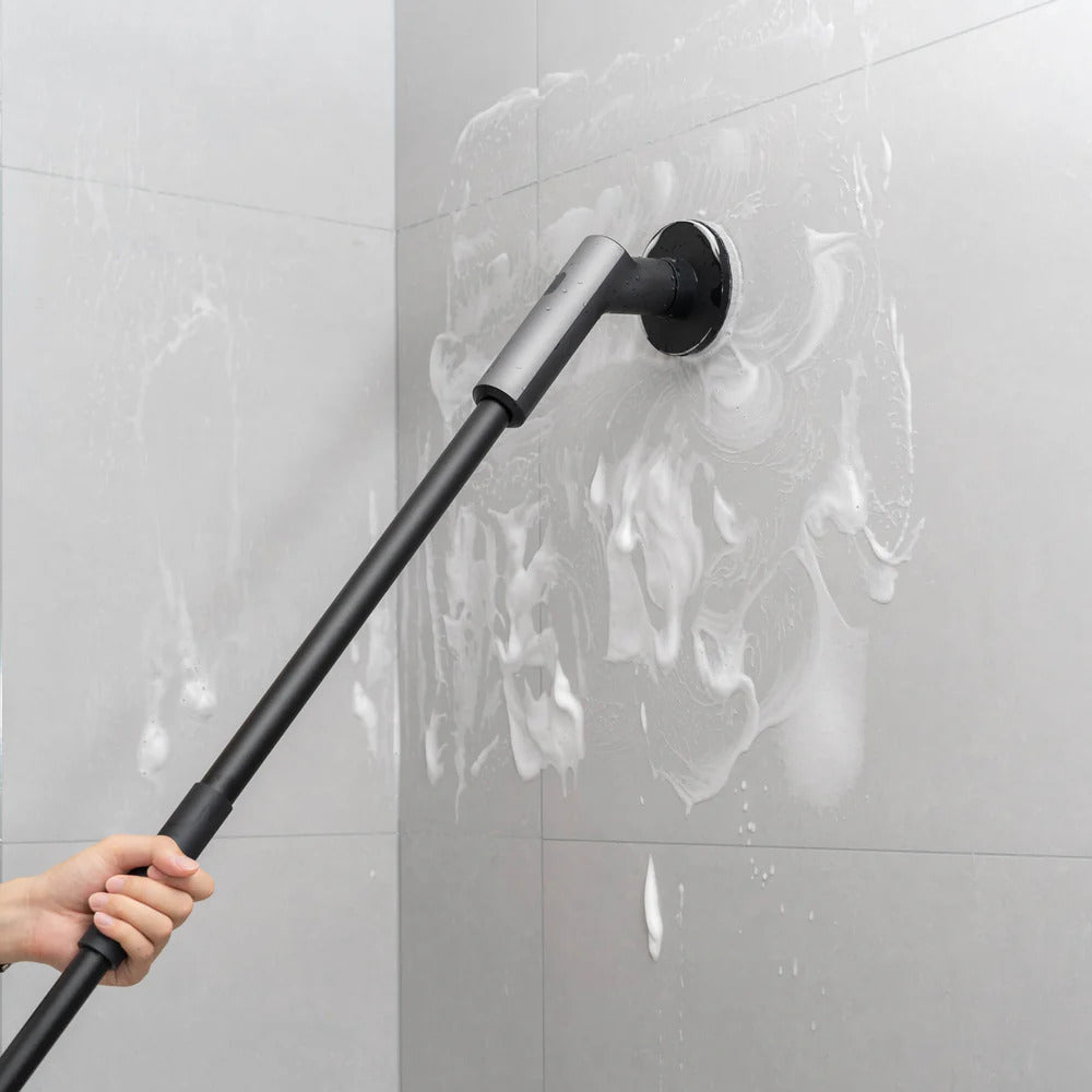 HOTO Cordless Spin Scrubber 6 Brush Head Set Person using a long-handled cleaning tool on a tiled wall