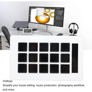 Desk setup with computer monitor, keyboard, and headphones on a white desk.