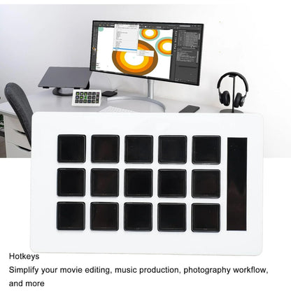 Desk setup with computer monitor, keyboard, and headphones on a white desk.