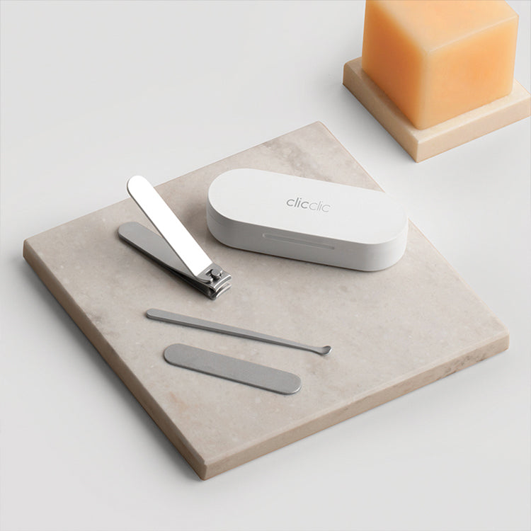HOTO Clicclic Three-Piece Nail Clipper Set Nail care set with nail clippers, cuticle pusher, and storage case on a stone surface.
