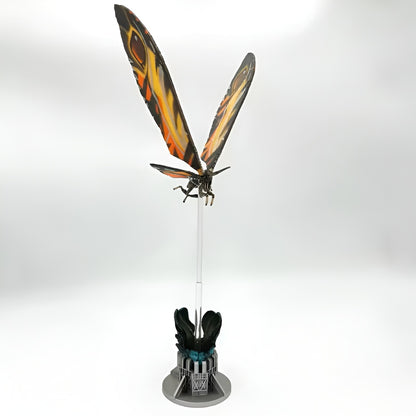 Decorative item with butterfly wings on a stand against a white background