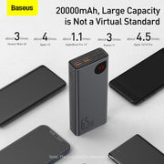 Baseus power bank with capacity display surrounded by smartphones on a light background