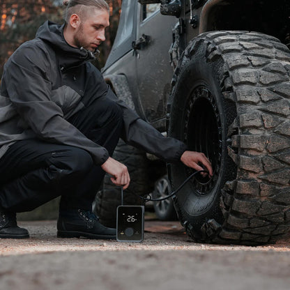 HOTO Air Pump Pro, Person checking tire pressure on a vehicle with a digital gauge