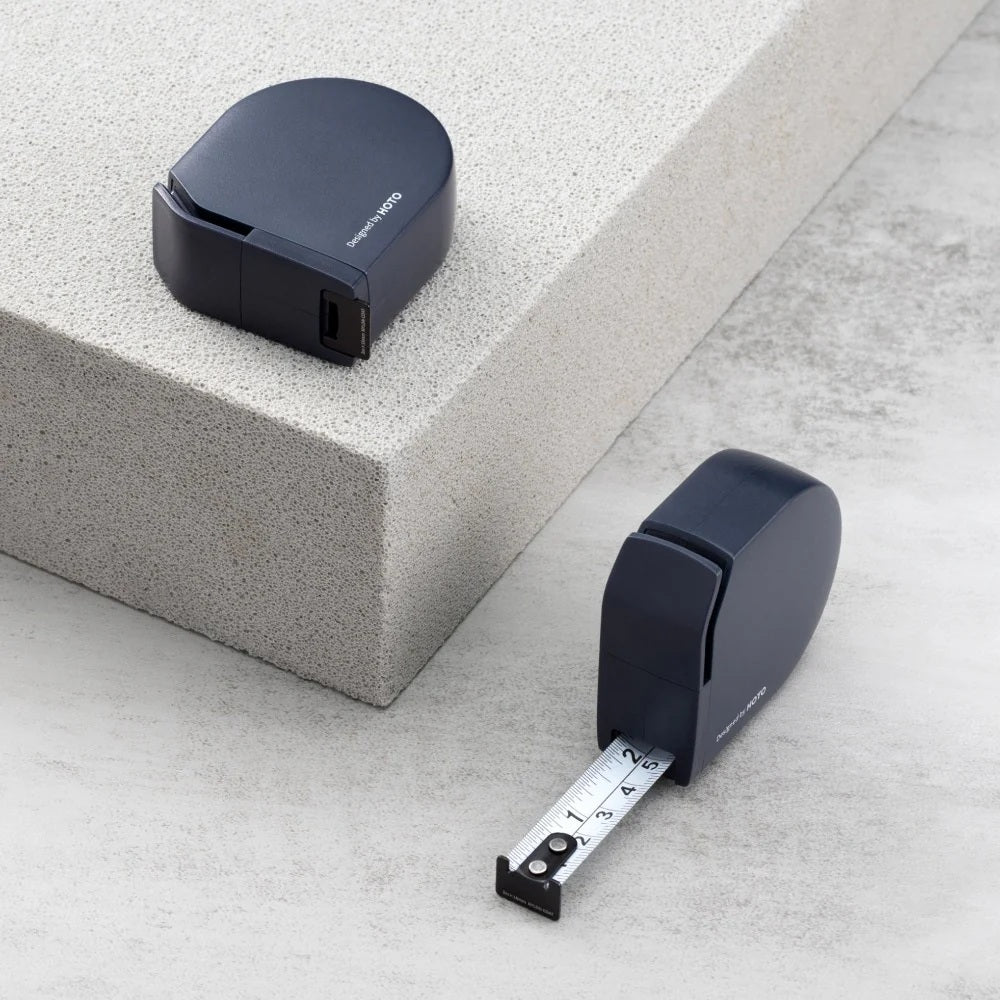 HOTO Self-locking Tape Measure, Black tape measure and measuring device on a concrete surface
