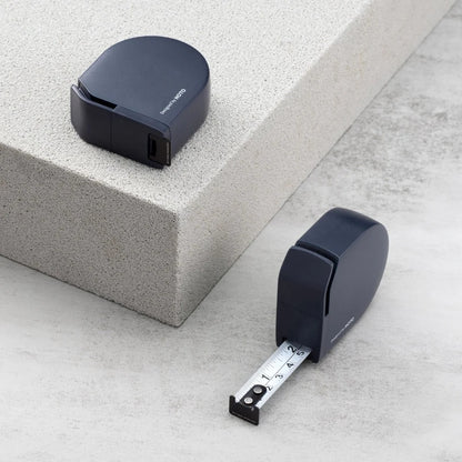 HOTO Self-locking Tape Measure, Black tape measure and measuring device on a concrete surface