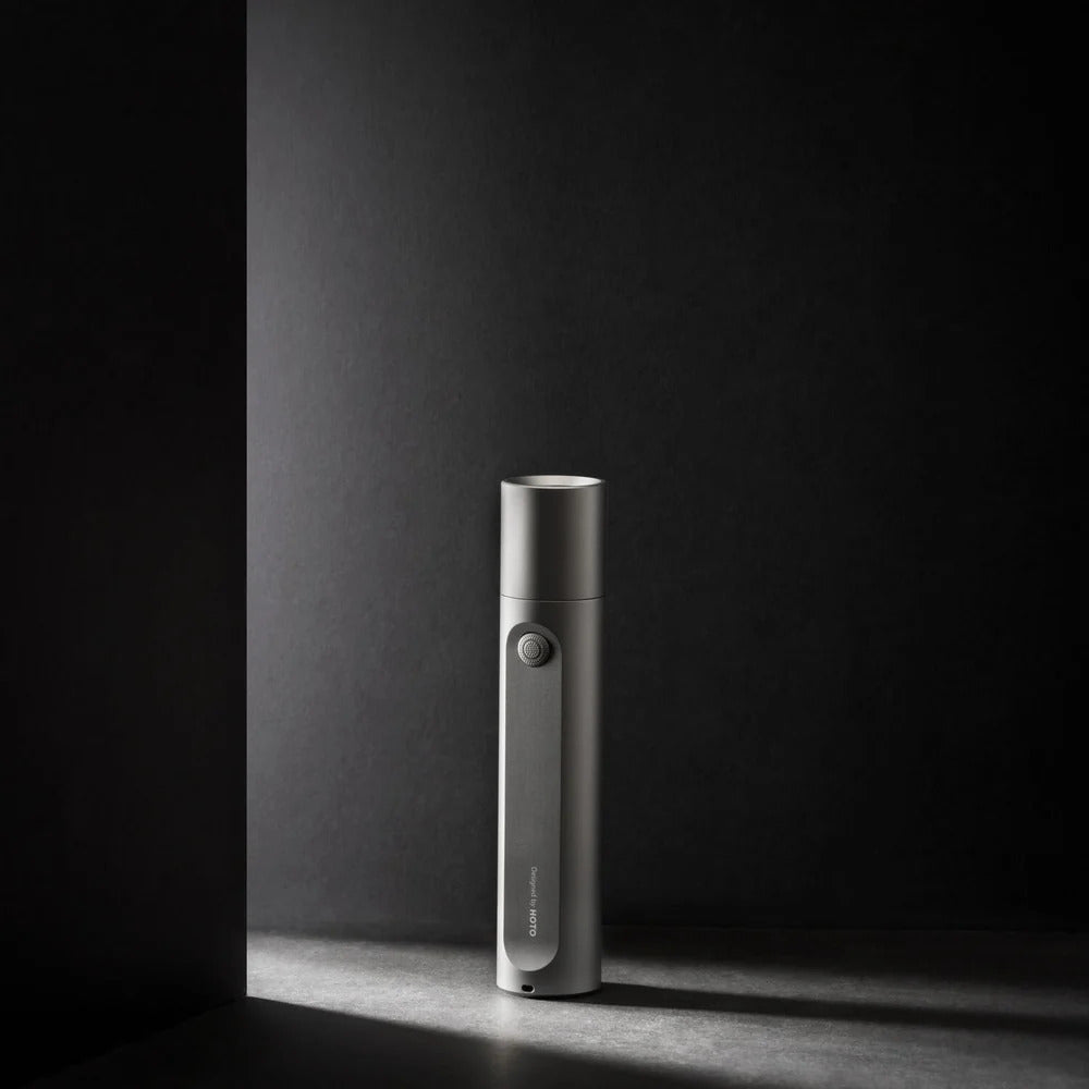HOTO Flashlight Fit 280 Lumens Rechargeable Torch Silver electronic device on a dark surface with a dark background