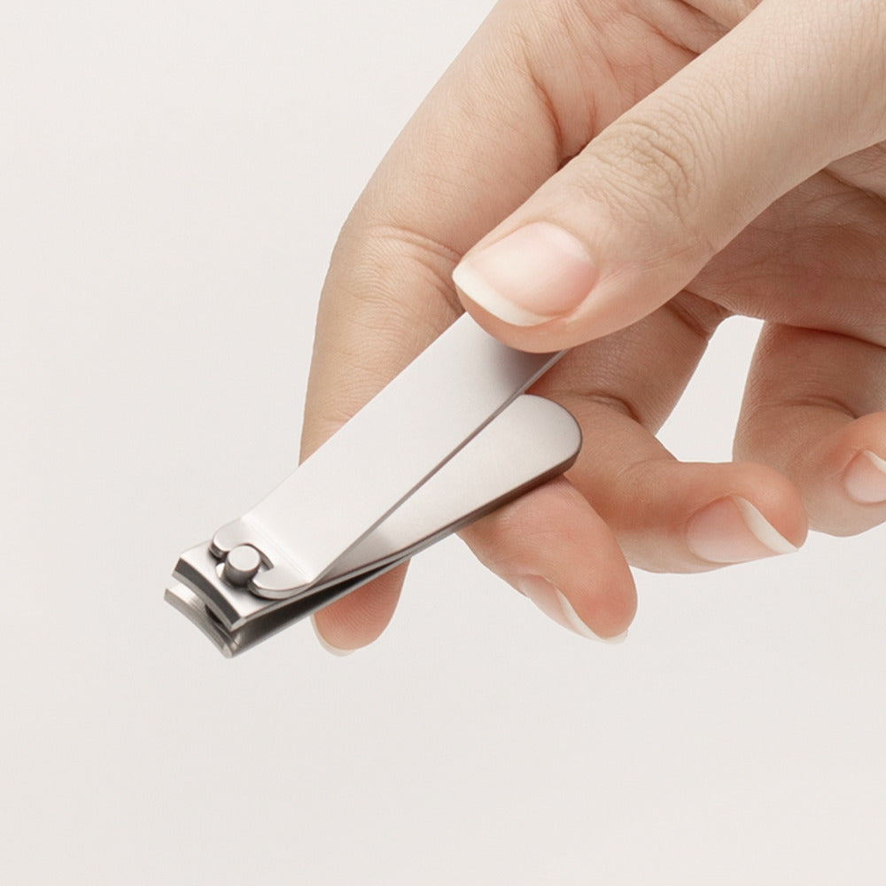 HOTO Clicclic Three-Piece Nail Clipper Set Hand holding a silver nail clipper against a light background