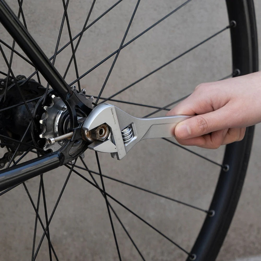 Person using a wrench on a bicycle wheel