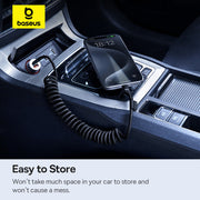Baseus car charger in a car's USB port with a smartphone on top, displayed in a dark car interior.