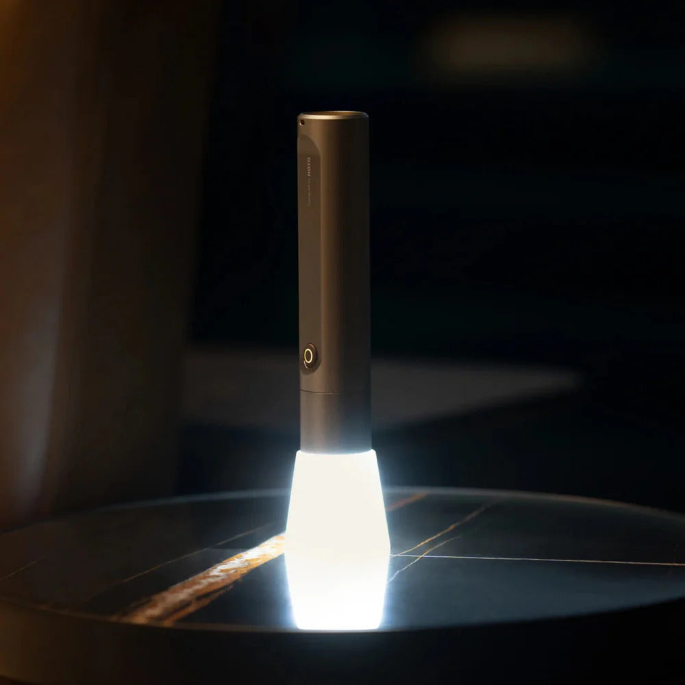 HOTO Flashlight Fit, Handheld flashlight on a dark surface with a blurred background