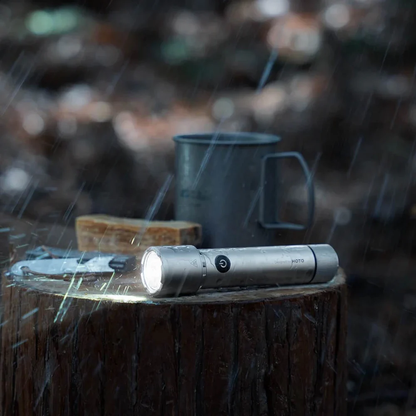 HOTO Flashlight Tactics 2300, Flashlight on a log with a mug and snack in the rain