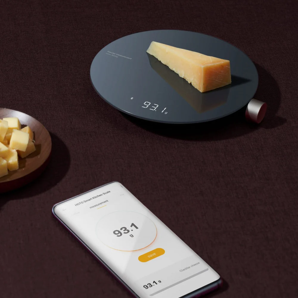HOTO Smart Kitchen Scale, Smart scale measuring a block of cheese with a smartphone app displayed on a dark surface.