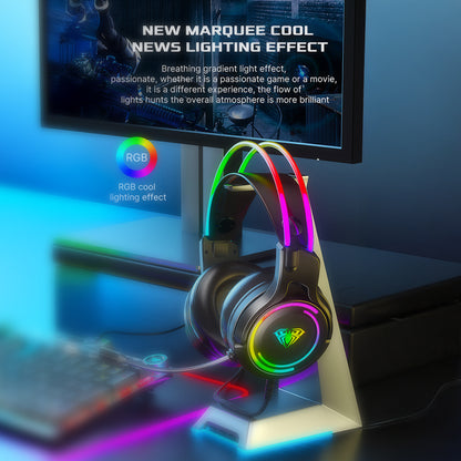 Gaming headset with RGB lighting on a desk setup, featuring a monitor and keyboard.