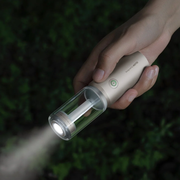 hoto-portable-camplight-rechargeable-camping-light-ipx6 Hand holding a flashlight with a dark background