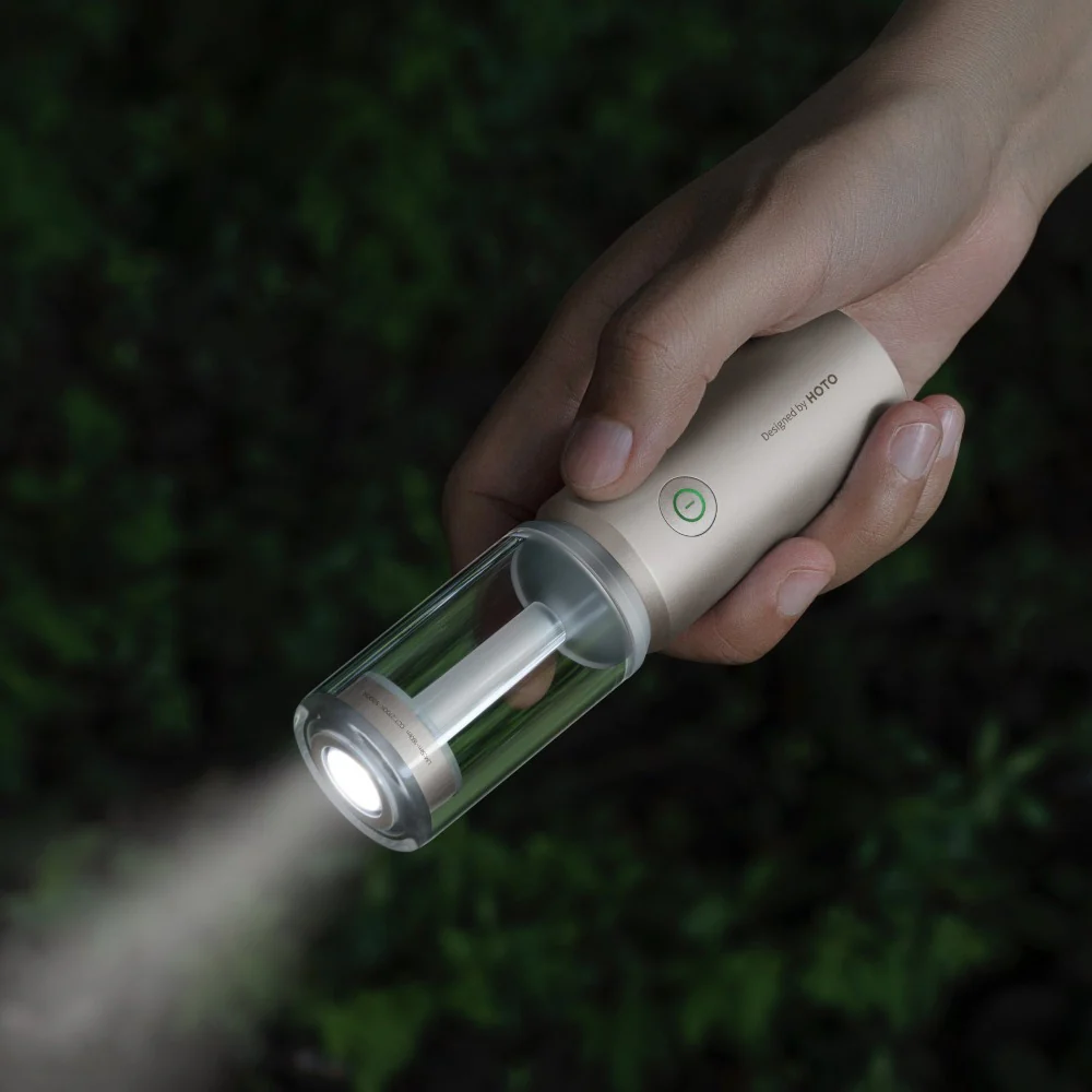 hoto-portable-camplight-rechargeable-camping-light-ipx6 Hand holding a flashlight with a dark background