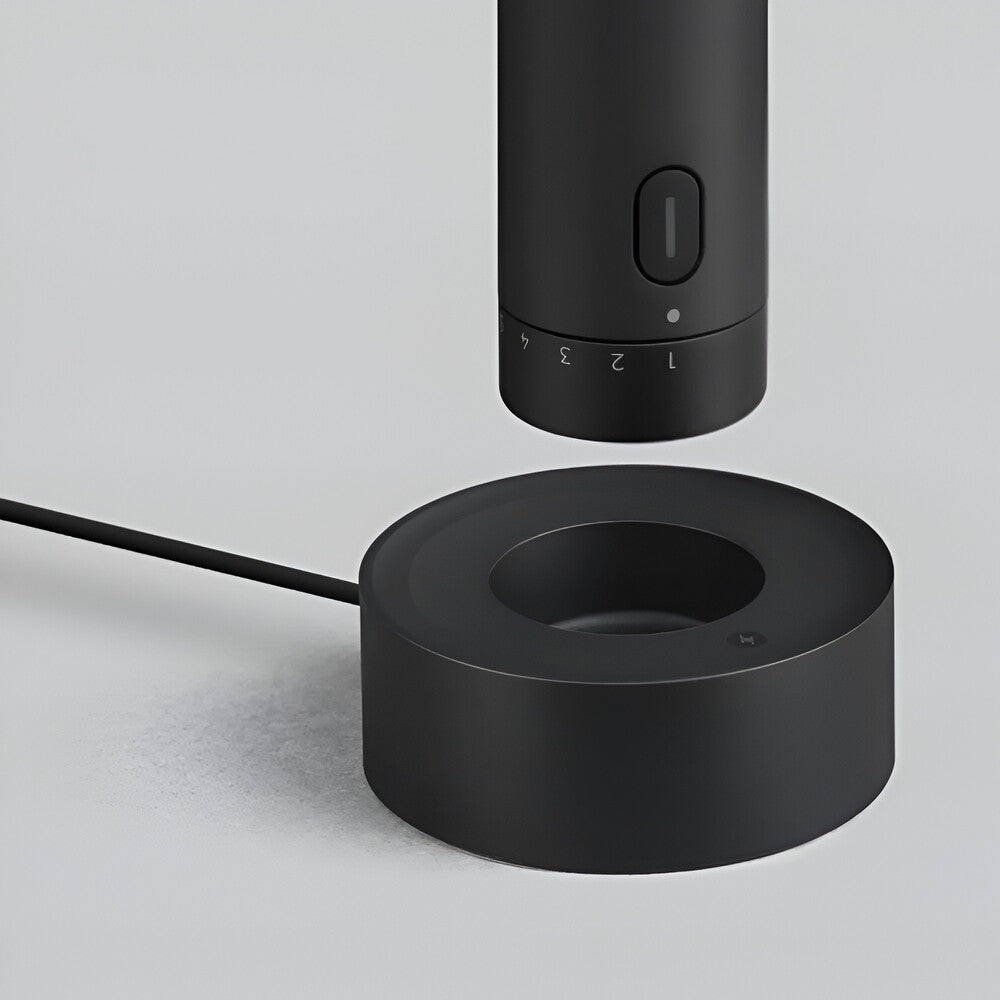 Black cylindrical device with a power button on a light gray background