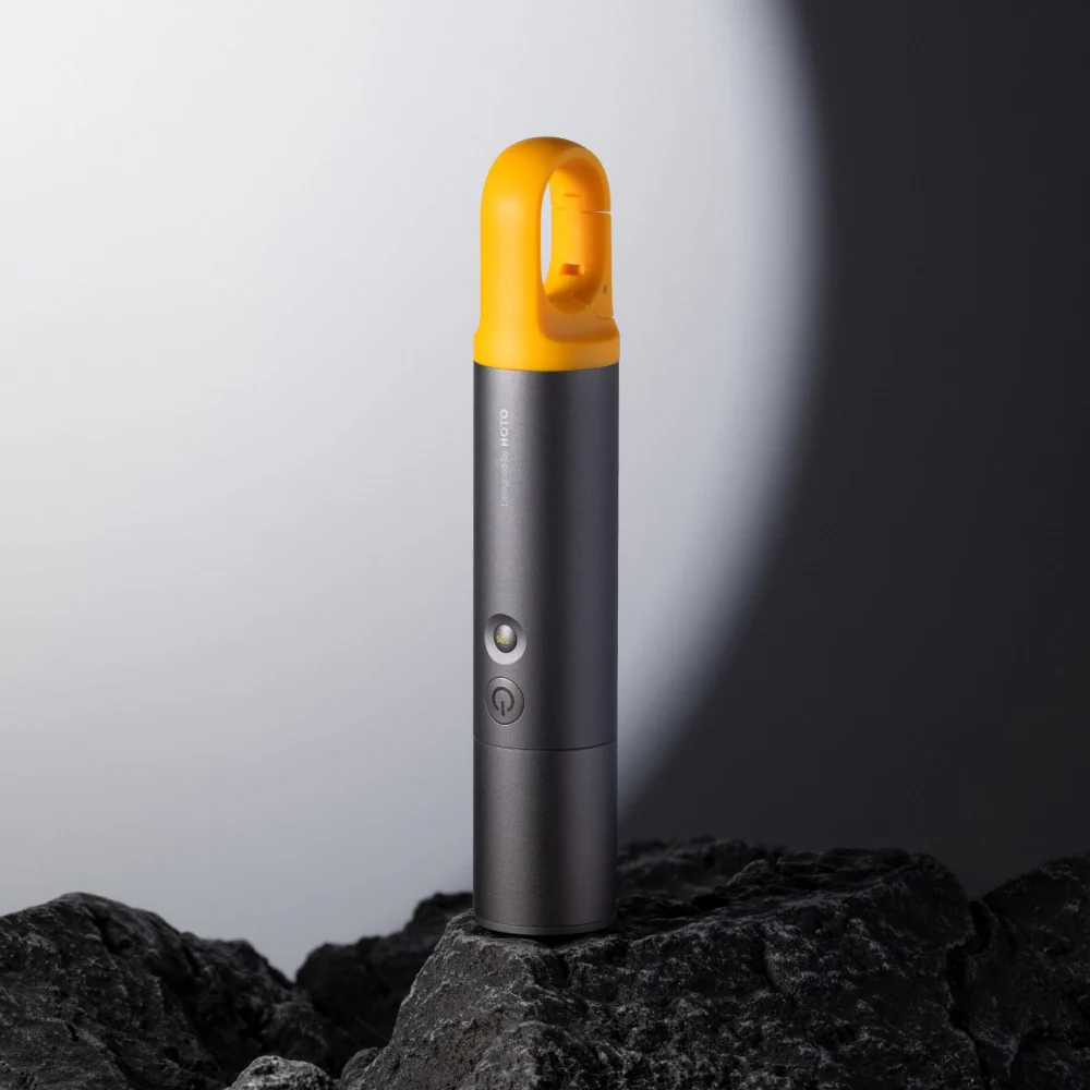HOTO Flashlight Lite, Black and yellow flashlight on a dark surface with a light beam effect