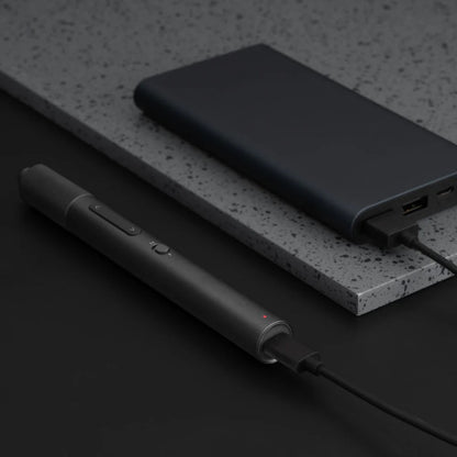 Black power bank and pen on a dark surface