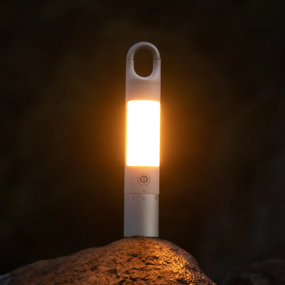 HOTO Flashlight Duo 1000 Lumens Dual-Light Rechargeable Torch Portable light on a rock with a dark background