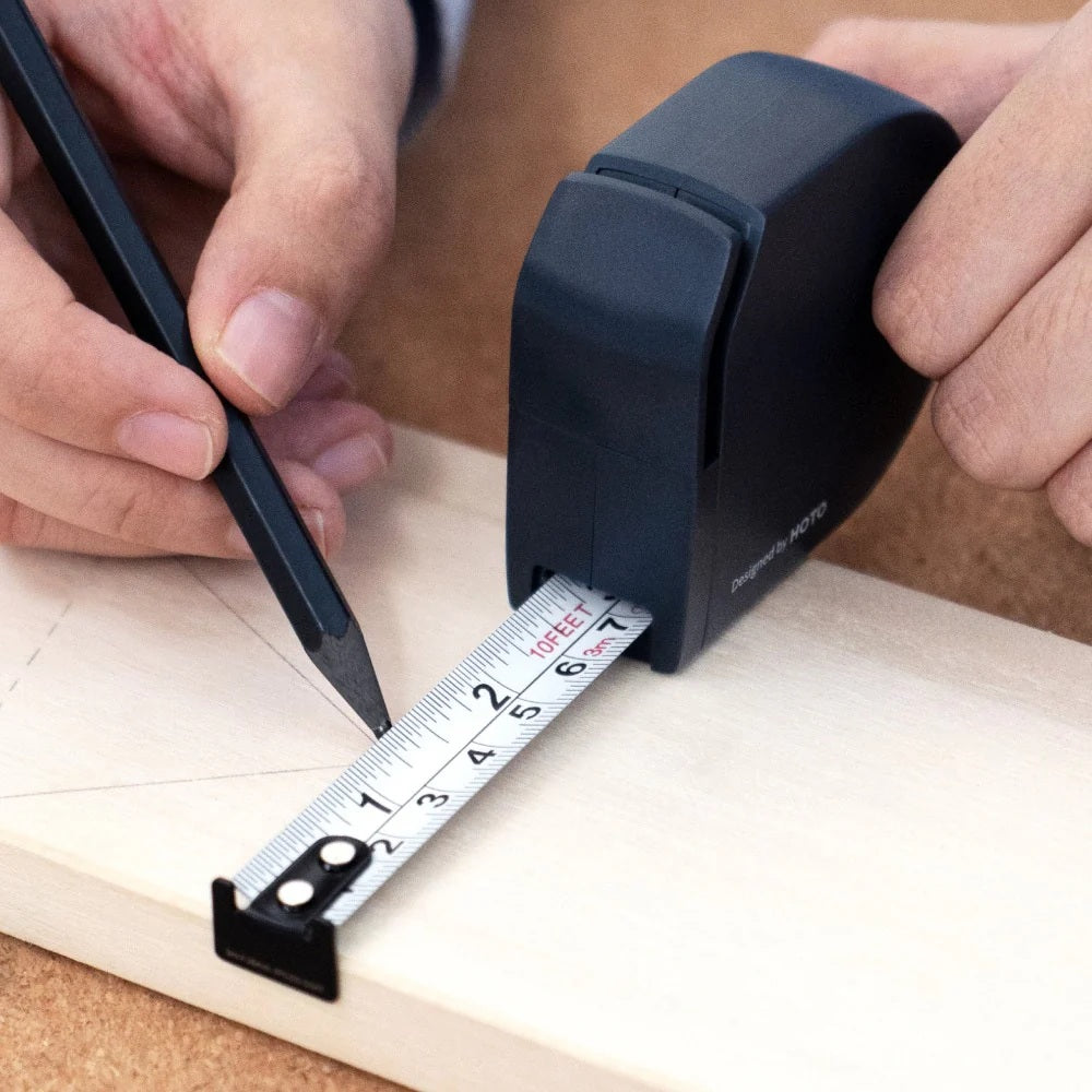 HOTO Self-locking Tape Measure, Person using a tape measure and pencil on a wooden surface