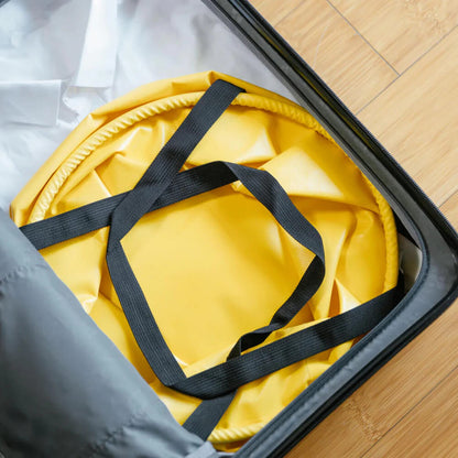 HOTO Outdoor Wash Kit, Yellow bag with black straps inside an open suitcase on a wooden floor.