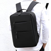 Black backpack worn by a person on a white background