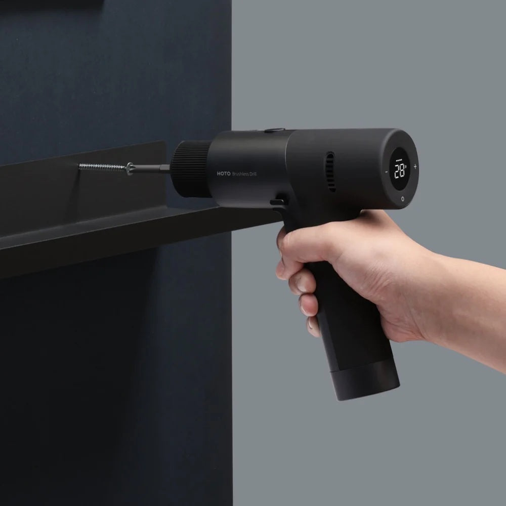 HOTO 12V Brushless Drill, Hand holding a black handheld tool against a gray background