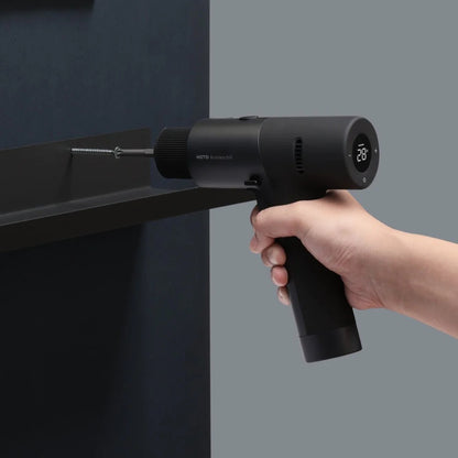 HOTO 12V Brushless Drill, Hand holding a black handheld tool against a gray background