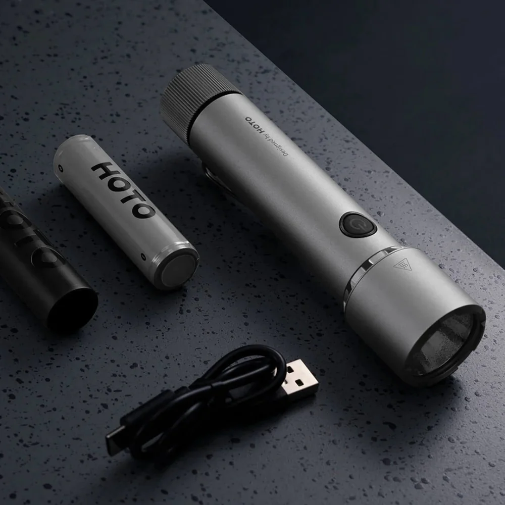 HOTO Flashlight Tactics 2300 Tactical Rechargeable Torch Silver flashlight with USB cable on a dark surface