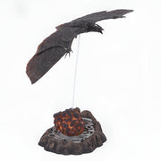 Decorative figure of a bird on a rock with lava, on a white background