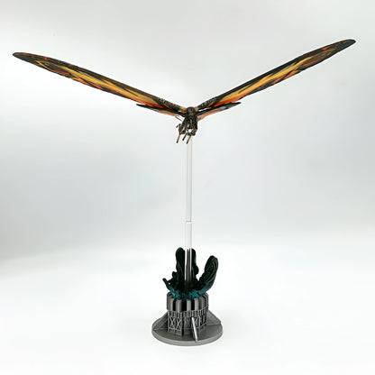 Model of a dragon with outstretched wings on a stand against a white background