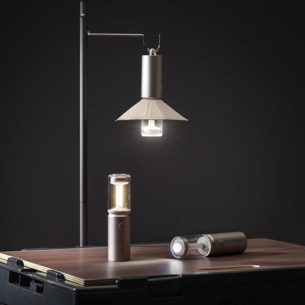 HOTO Camplight, Modern lamp and portable light sources on a wooden surface with a dark background