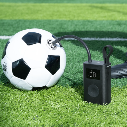 HOTO Electric Air Pump, Soccer ball being inflated with a digital air pump on a grass field