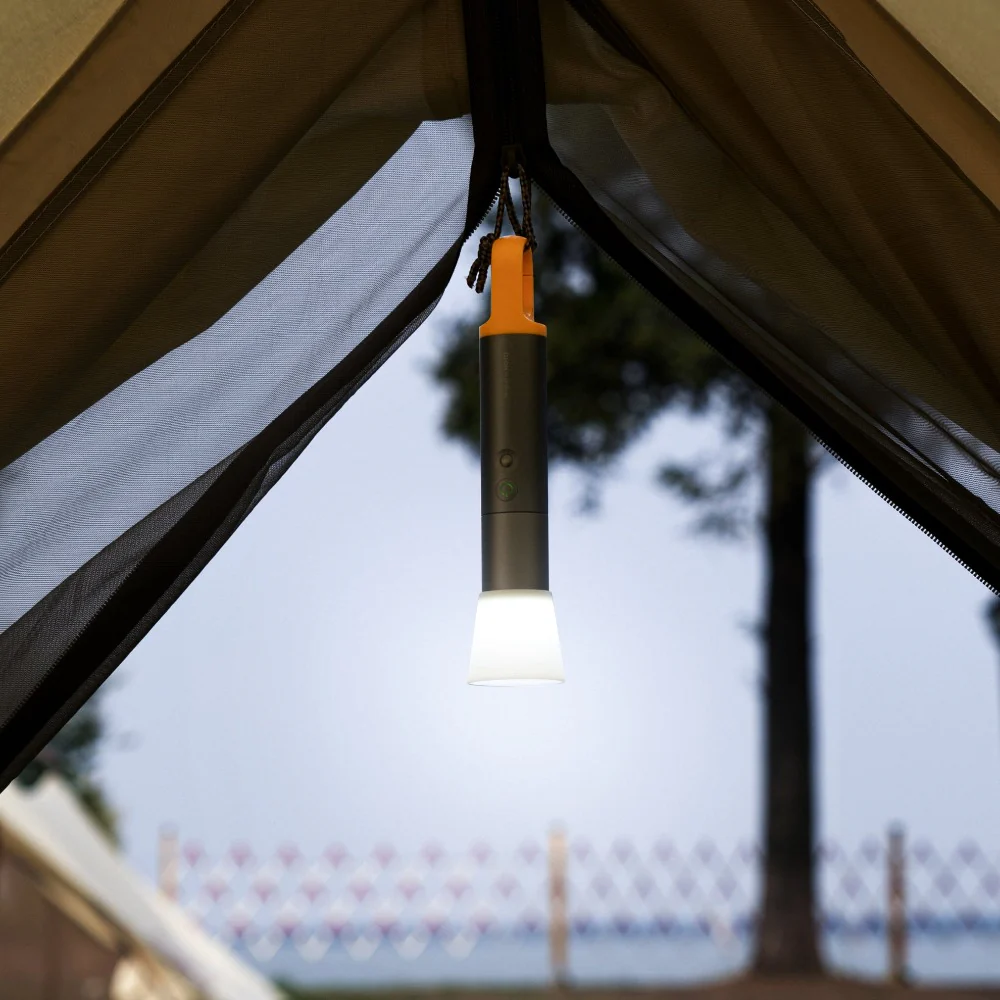 HOTO Flashlight Lite, Portable light hanging from a tent with a blurred outdoor background