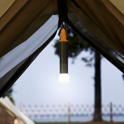 HOTO Flashlight Lite, Portable light hanging from a tent with a blurred outdoor background