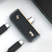 Rokid Hub USB‑C Adapter (Pass‑Through Charging, Switch Dock Mode, Dual USB‑C Out) Black and gold electronic device with multiple connectors on a light gray background