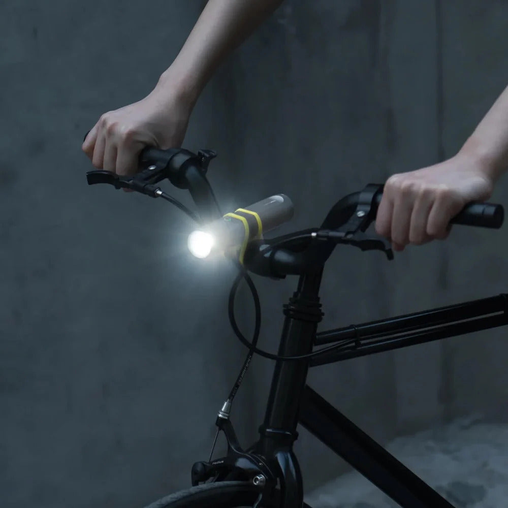 HOTO Flashlight Fit 280 Lumens Rechargeable Torch Person holding a bicycle handlebar with a light attached against a dark background