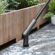 HOTO Cordless Spin Scrubber 6 Brush Head Set Gardening tool on a stone surface with plants in the background