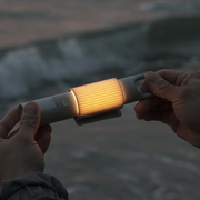 HOTO Flashlight Duo 1000 Lumens Dual-Light Rechargeable Torch Two hands holding a glowing flashlight against a blurred natural background