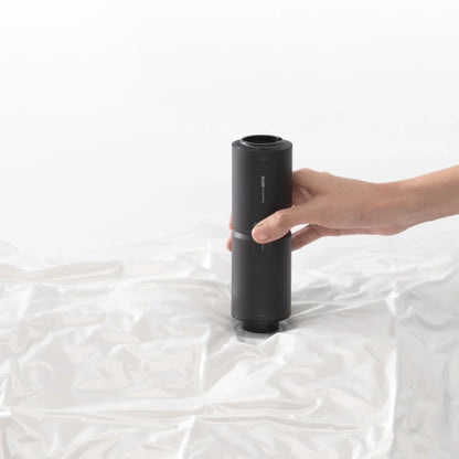 Hand holding a black cylindrical object on a white background